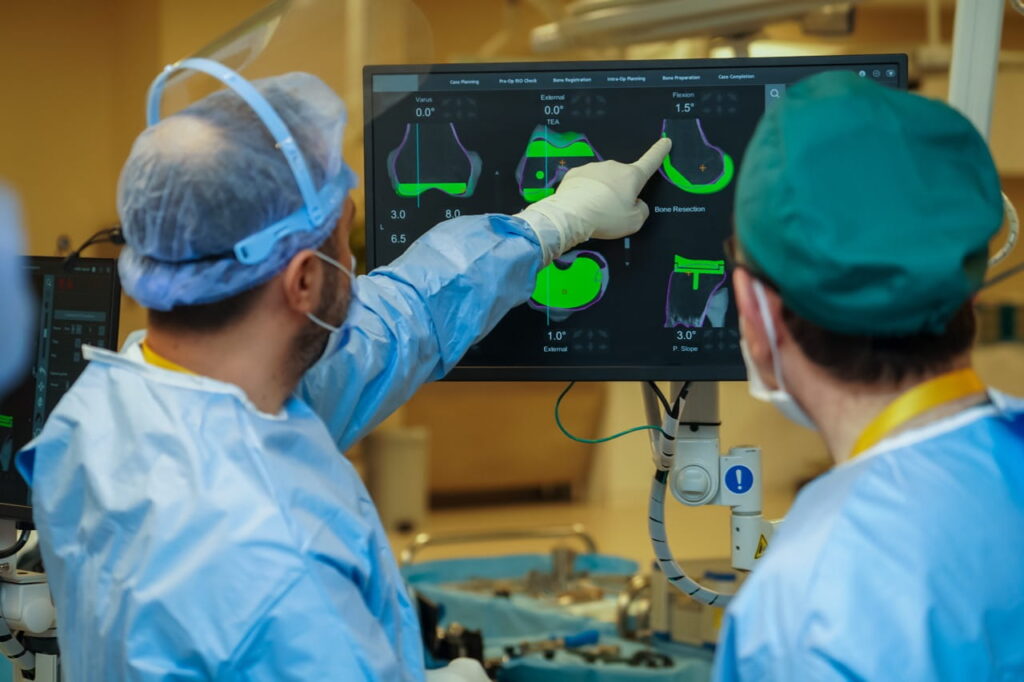Doctors pointing to an imaging screen in a surgical setting