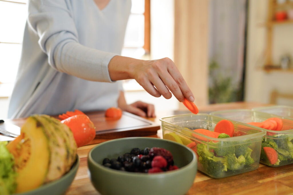 Close up of a woman meal prepping healthy food