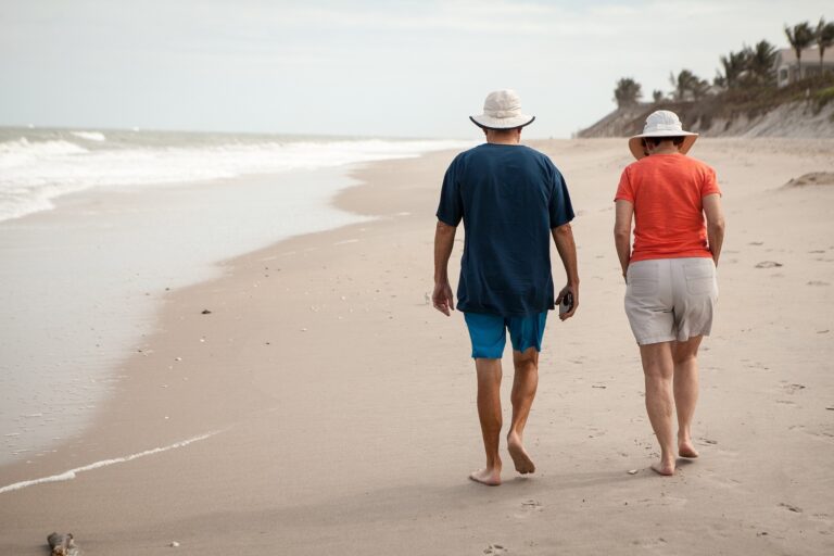 two people walking on a beach
