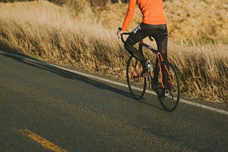 bicyclist riding on the side of a road