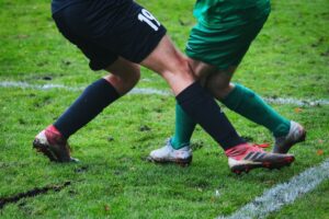 close up of two soccer player's knees getting tangled