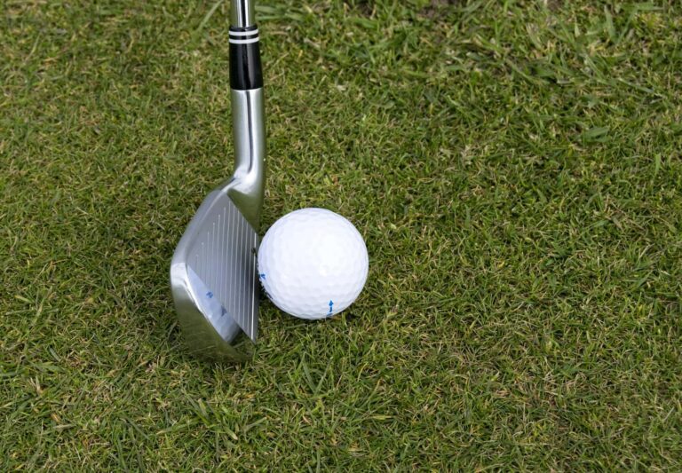 close up of putter about to hit a golf ball