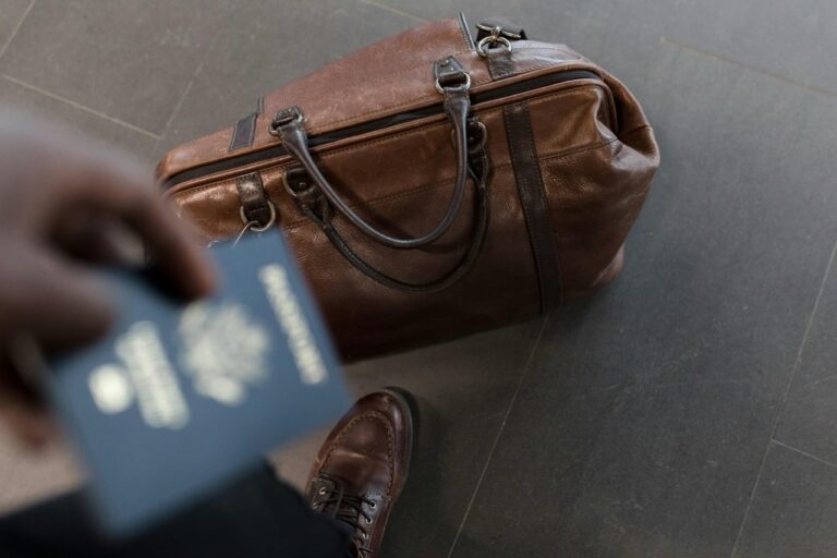 Man's luggage laying on the ground at an airport