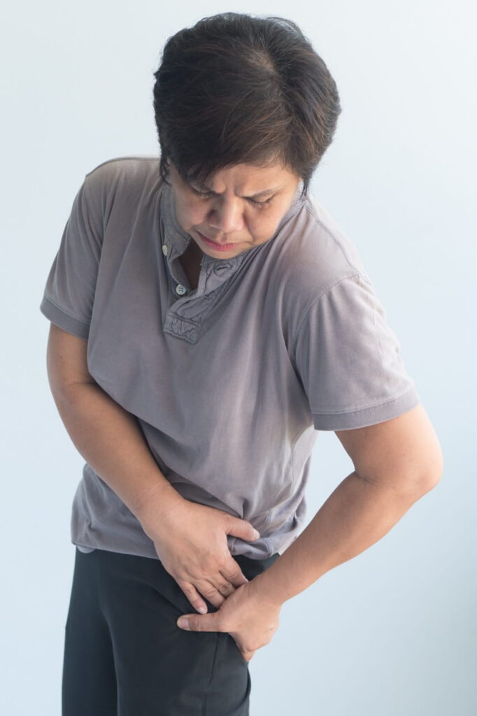 Woman grabbing at her hip in distress