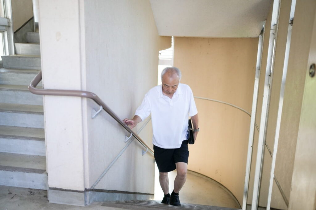 Older man walking up set of stairs