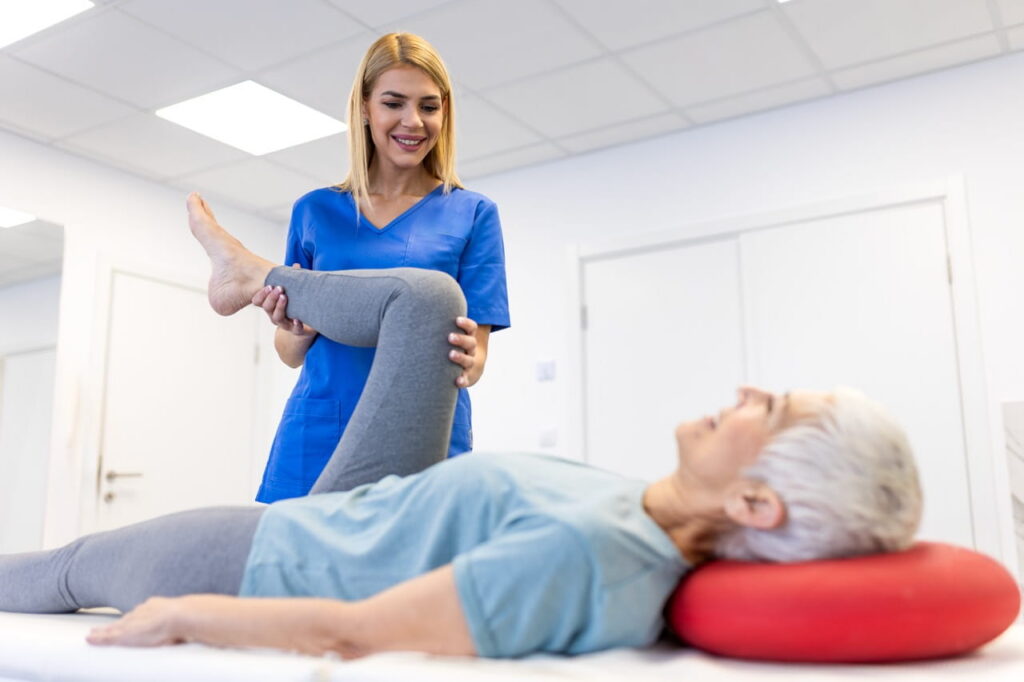 Physical therapist bending patient's knee