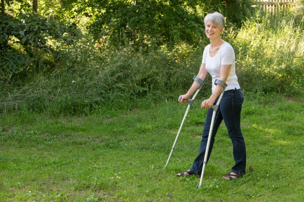 Woman standing outdoors with walking assistance device