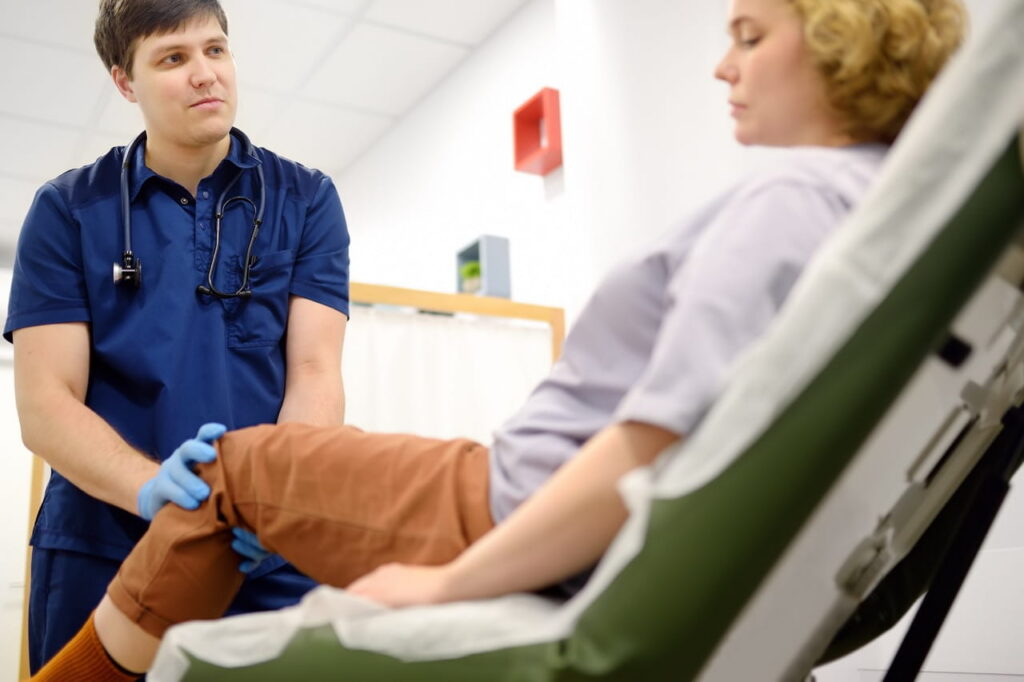 Physician assessing a female patient's knee